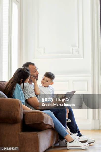 cute boy spending leisure time with parents - familie sofa stock pictures, royalty-free photos & images