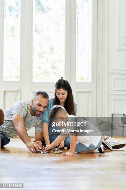 het spelen van de familie met speelgoedauto's in woonkamer - boy floor stockfoto's en -beelden