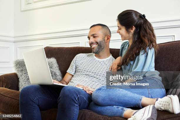 happy mid adult couple talking at home - familie sofa stock pictures, royalty-free photos & images
