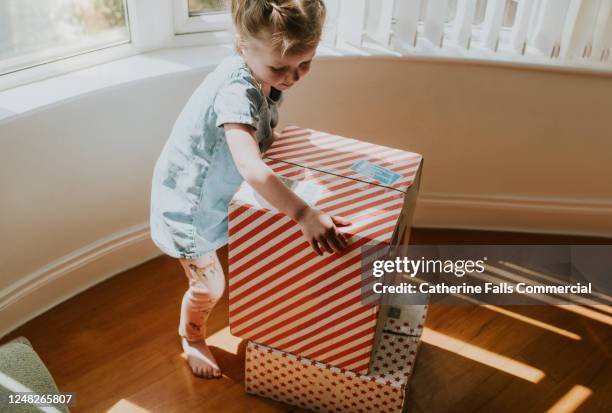 girl picking up a box - arrival stamp stock pictures, royalty-free photos & images