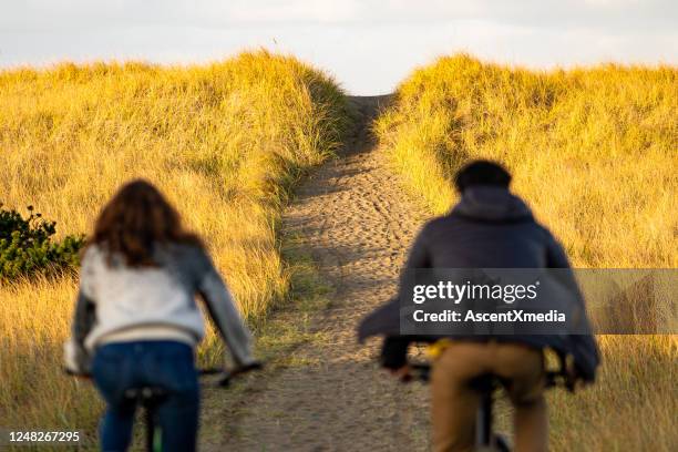 年輕夫婦騎脂肪自行車在沿海小徑 - fat guy on beach 個照片及圖片檔
