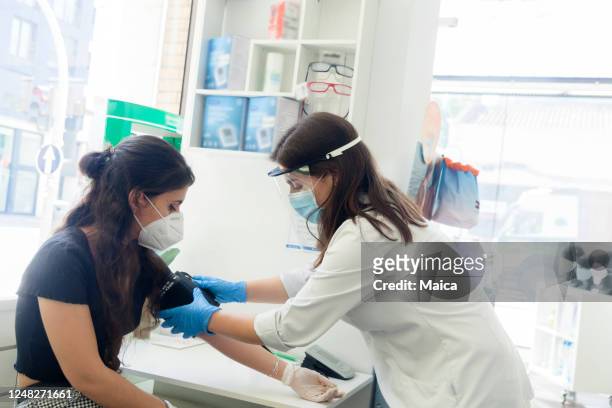 taking blood pressure in the pharmacy - pharmacy mask stock pictures, royalty-free photos & images