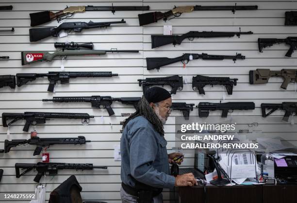 Earl J. Brake, SR, owner of EJB's Gun Shop looks at a computer in Capitol Heights, Maryland on March 14, 2023. - EJB's Gun Shop has been open for 3...