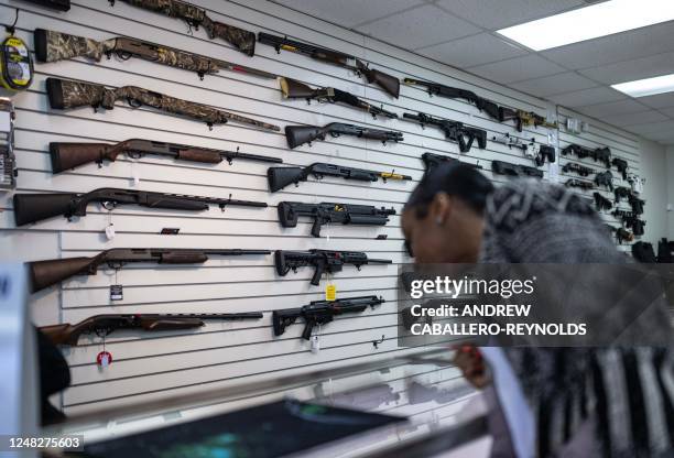 Customer looks at guns in EJB's Gun Shop in Capitol Heights, Maryland on March 14, 2023. - EJB's Gun Shop has been open for 3 years and is one of the...
