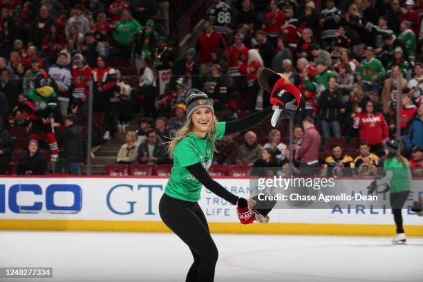 Member of the Chicago Blackhawks ice-crew picks up hats after Taylor Raddysh of the Chicago Blackhawks scores a hat-trick against the Boston Bruins...
