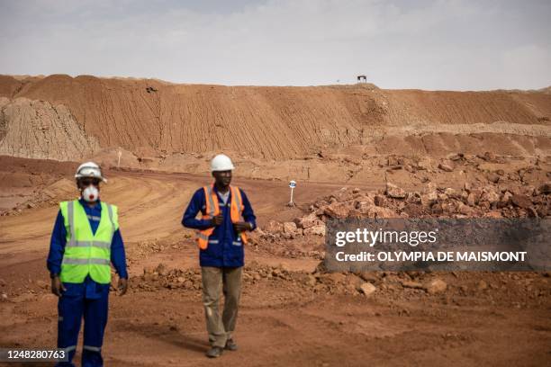 Mine workers stand by the residual dump at the Cominak mine near Arlit on March 8, 2023. - The Akouta Mining Company , operated in the town of Akokan...