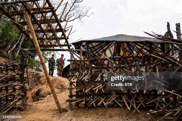 In this photo taken on March 9, 2023 members of ethnic rebel group Ta'ang National Liberation Army stand guard at a checkpoint near Namhsan Township...