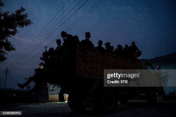 In this photo taken on March 9, 2023 members of ethnic rebel group Ta'ang National Liberation Army sit on a truck at a checkpoint near Namhsan...