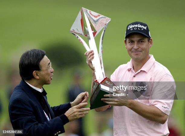 England's David Howell receives his trophy from Vincent Cheng Chairman of HSBC China, after winning the five million USD HSBC Champions tournament in...