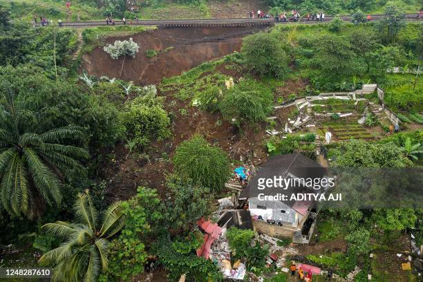 This aerial picture shows an evacuation effort by a rescue team to find victims buried in a landslide that was triggered by heavy rainfall in Bogor,...