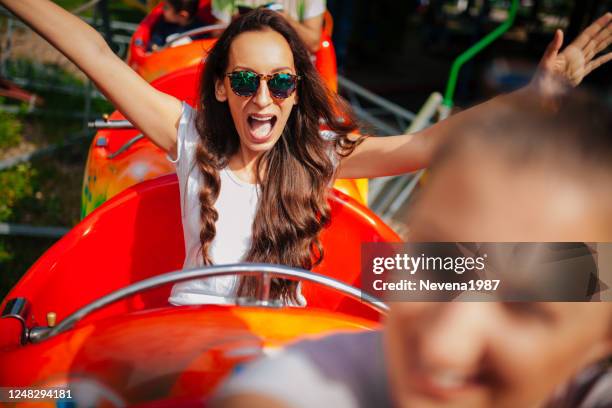 we gonna have fun at amusement park - young woman screaming on a rollercoaster stock pictures, royalty-free photos & images