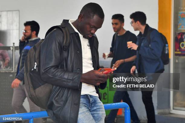 An African student checks his mobile phone in the campus of ESPRIT university, specialised in engineering and management courses, on March 13, 2023...