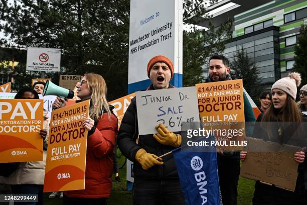 Demonstrators hold placards as they take part in a protest by junior doctors, amid a dispute with the government over pay, outside of Saint Mary's...