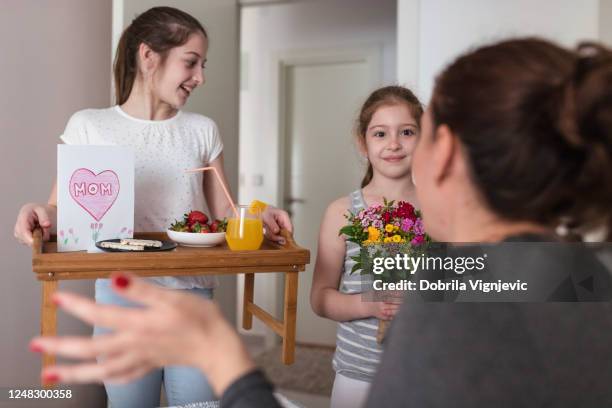 happy girls getting her mother breakfast in bed - mother's day breakfast stock pictures, royalty-free photos & images