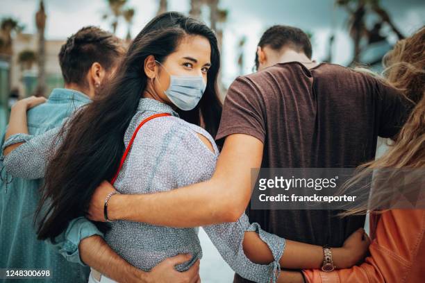 friends walking together wearing the face mask - arm in arm stock pictures, royalty-free photos & images