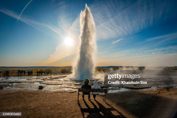 couple watching strokkur hot geyser at haukadalur valley - geyser ストックフォトと画像