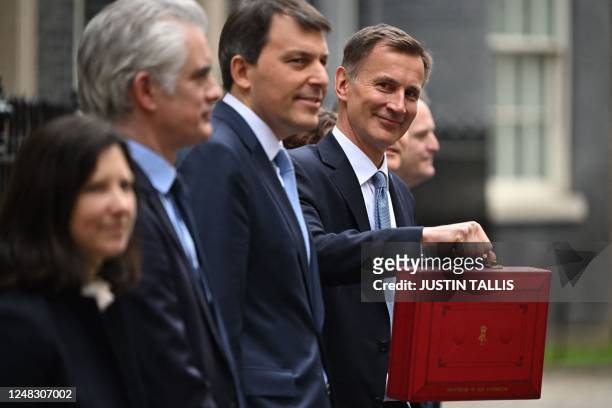 Britain's Chancellor of the Exchequer Jeremy Hunt poses with the red Budget Box as he leaves 11 Downing Street in central London on March 15 to...