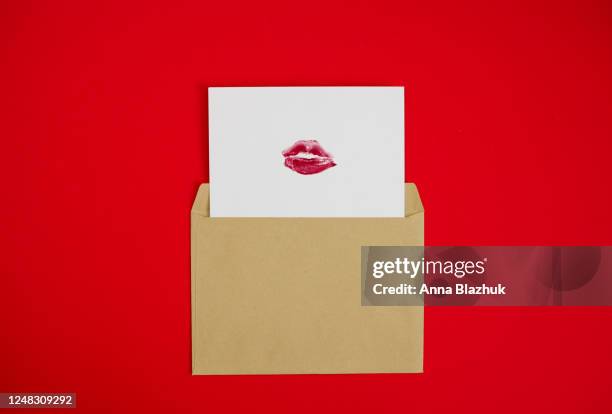 kiss day concept, card with red lipstick kiss in the craft envelope, valentine's day greeting - lippenstift afdruk stockfoto's en -beelden