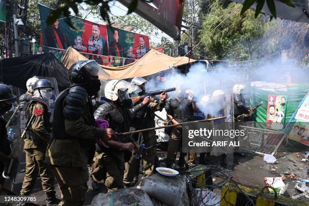 Riot police fire tear gas shells towards supporters of former prime minister Imran Khan gathered near Khan's house to prevent officers from arresting...