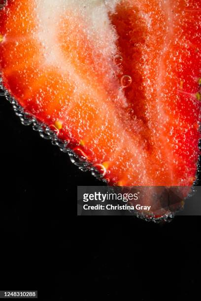 close-up strawberry slice in carbonated water - erdbeeren freisteller stock-fotos und bilder