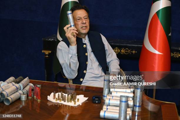 Former Pakistan's prime minister Imran Khan speaks during an interview with AFP at his residence in Lahore on March 15 while displaying teargas...