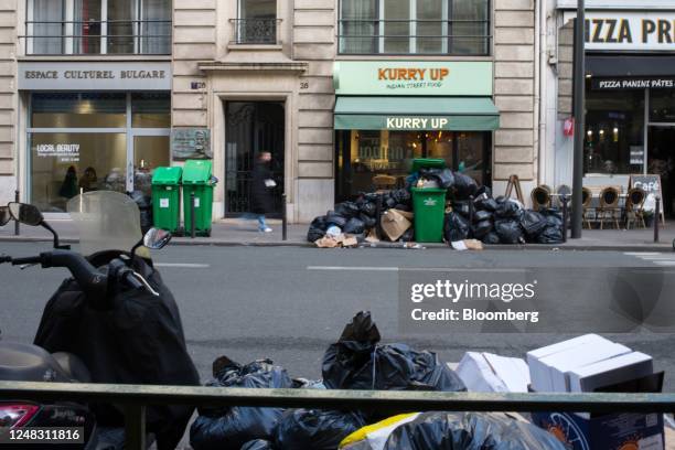 Overflowing garbage bins and bags of trash left on the street in the 8th arrondissement of Paris, France, on Wednesday, Feb. 15, 2023. In some French...