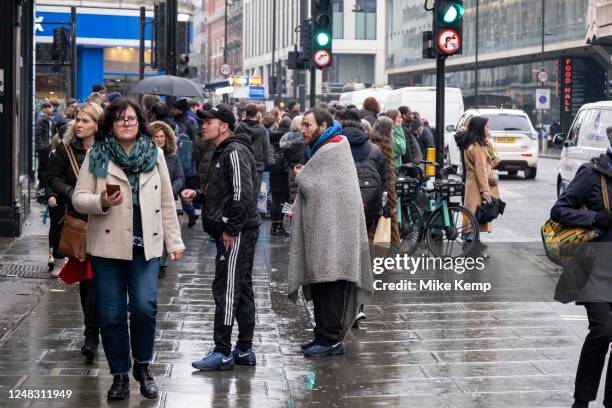 Men forcefully asking passers by for cigarettes and money on Oxford Street on 9th March 2023 in London, United Kingdom. The scene is illustrative of...