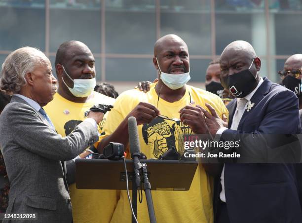 Philonise Floyd , stands with Rev. Al Sharpton and his lawyer Benjamin Crump , as he is overcome with emotion while speaking to the media in front of...