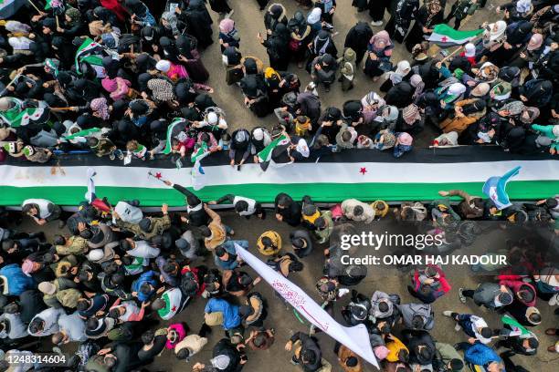 This aerial view shows women and men demonstrators gathering for a rally to mark the 12th anniversary of the start of the uprising against Syrian...