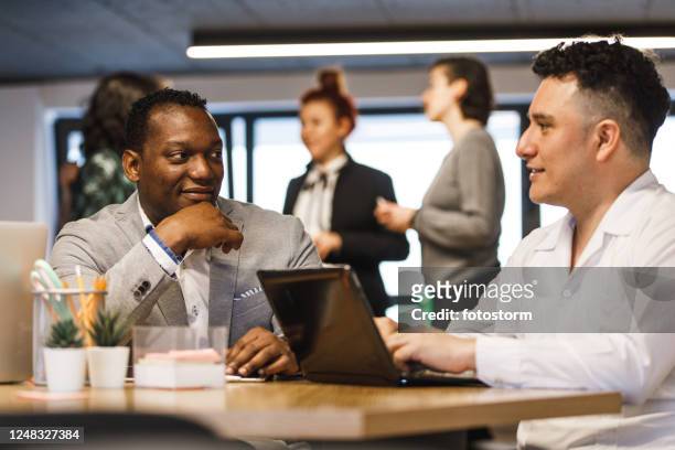 latino administrative operatives having a relaxing conversation - hub stock pictures, royalty-free photos & images
