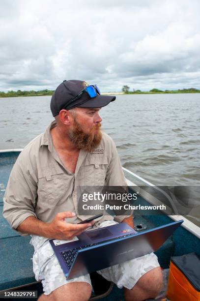 Game fishing guide, Renier van Zyl, owner of Big Five Fishing Safaris, works from "home" checking his phone and his computer organising angling tours...