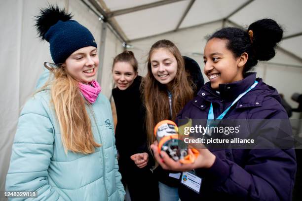 March 2023, Lower Saxony, Rotenburg : Participants Elisa , Sophia, Charlotte and Rahel from the "ClouDDSat" team from Dresden hold a mini-satellite...