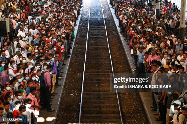 Commuters wait to board a train at the Fort railway station during a nationwide strike in Colombo on March 15, 2023. - Sri Lanka deployed armed...