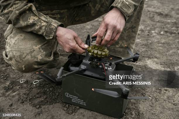 Ukrainian serviceman attaches a hand grenade on a drone to use in an attack, near Bakhmut, in the region of Donbas, on March 15, 2023.