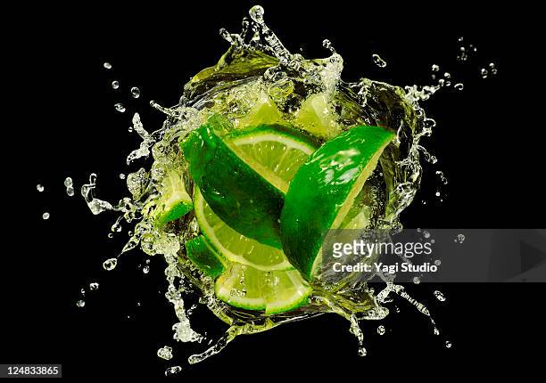 lime  splashing into cocktail, close-up. - splashing cocktail stock pictures, royalty-free photos & images