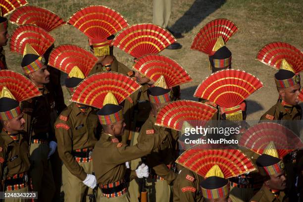 An Indian Border Security Force soldier helps his comrade in adjusting his uniform before their passing out parade at a garrison on March 15, 2023 in...