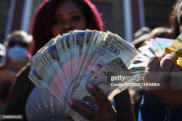 Venezuelan public worker holds out of circulation Bolivar bills during a demonstration outside the Ministry of Labor to demand the Government salary...