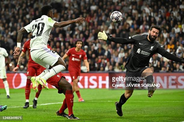 Liverpool's Brazilian goalkeeper Alisson Becker saves Real Madrid's Brazilian forward Vinicius Junior's effort on goal during the UEFA Champions...