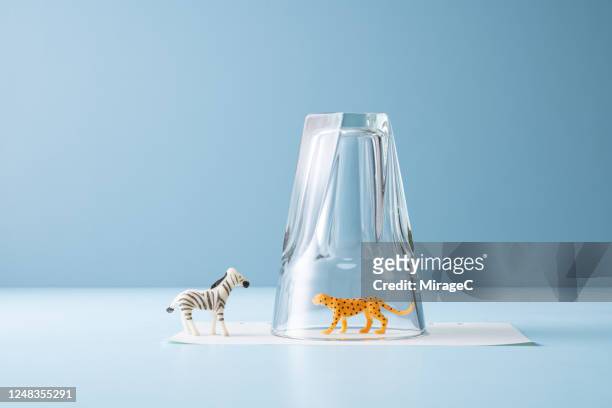 toy animal trapped in a drinking glass - rappresentazione di animale foto e immagini stock
