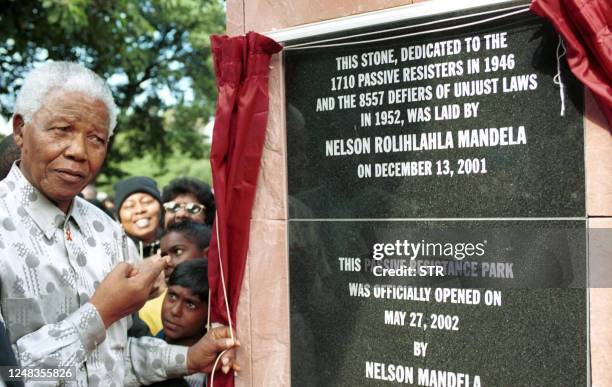 Former South African President Nelson Mandela unveils the Passive Resistance Monument erected to honor the role of African and Indian activists...