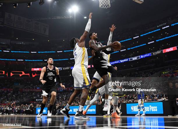 Paul George of the Los Angeles Clippers scores a basket against Kevon Looney of the Golden State Warriors during the first half of the game at...