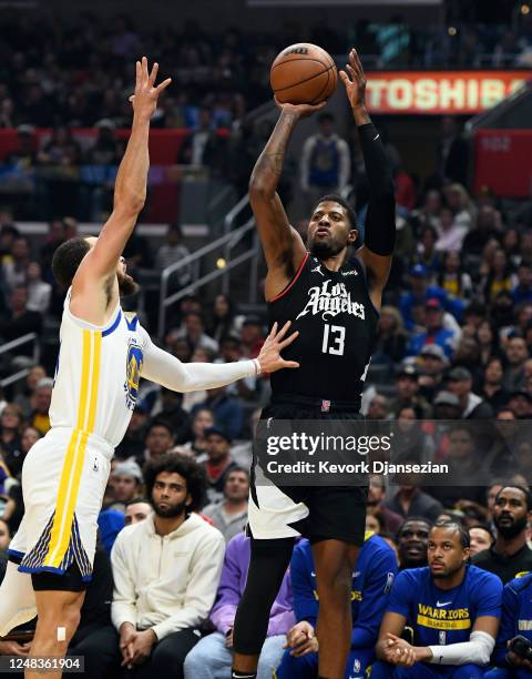 Paul George of the Los Angeles Clippers scores a three-point basket over Stephen Curry of the Golden State Warriors during the first half of the game...