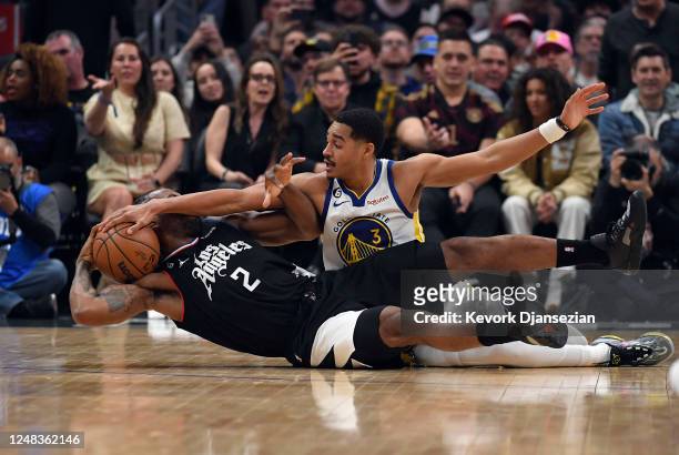 Kawhi Leonard of the Los Angeles Clippers battles for the ball with Jordan Poole of the Golden State Warriors during the first half of the game at...