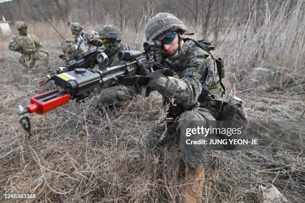 South Korean soldier aims his rifle during a South Korea-US joint drill at a military training field in the border city of Paju on March 16 as part...