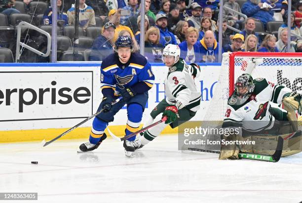 St. Louis Blues center Robert Thomas and Minnesota Wild defenseman John Klingberg compete for a loose puck during a NHL game between the Minnesota...