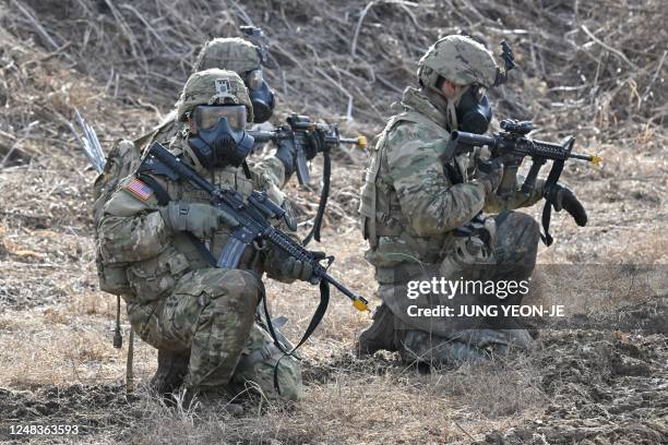 Soldiers wearing gas masks participate in a South Korea-US joint drill at a military training field in the border city of Paju on March 16 as part of...