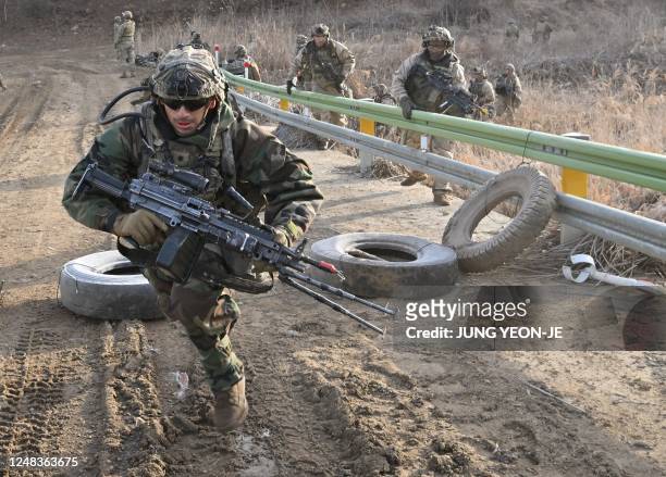 Soldiers move to a position during a South Korea-US joint drill at a military training field in the border city of Paju on March 16 as part of the...