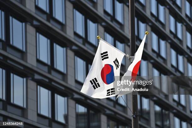 South Korea and Japan national flags are seen fluttering in the wind near the Parliament building on March 16 in Tokyo, Japan, as South Korean...