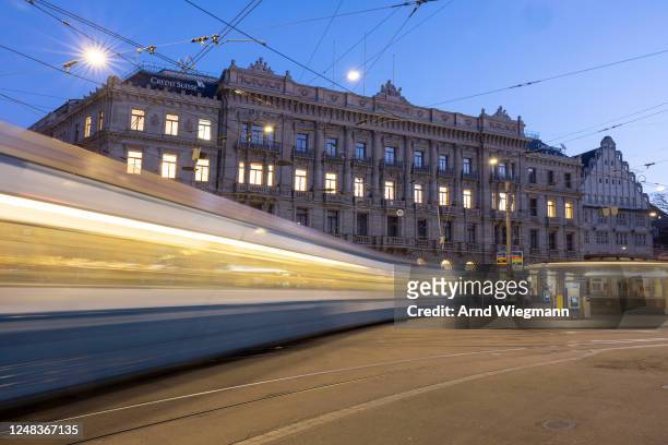 Long exposure shows a tram driving past the global headquarters of Swiss bank Credit Suisse the day after its shares dropped approximately 30% on...