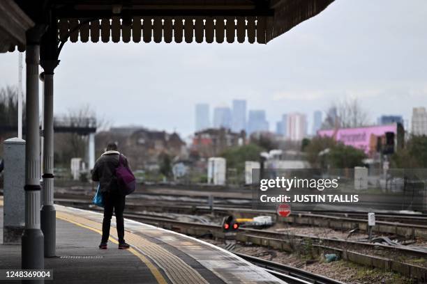 Commuter waits for a train at Clapham Junction station in south London on March 16, 2023 as train drivers staged a strike over pay, the latest in a...